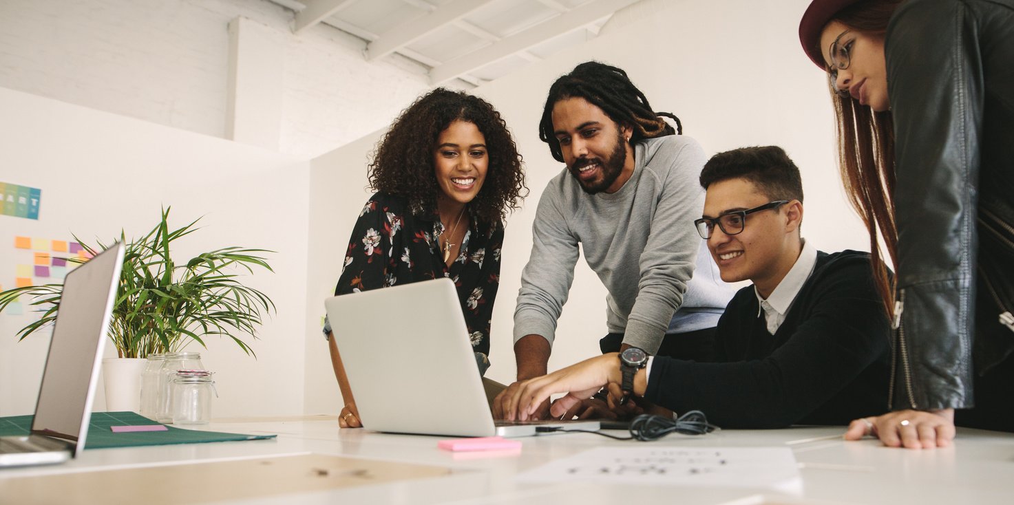 Office Mates Working Together as a Team on a Computer